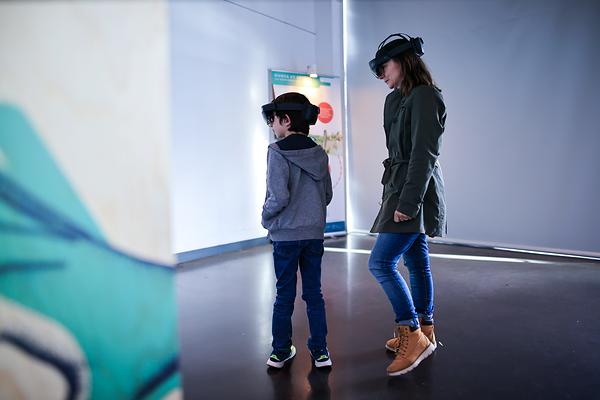 Des visiteurs munis de casques HoloLens explorent le parcours de l'exposition Dunes & Forêts : les gardiennes du littoral